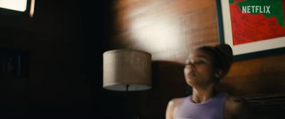 a woman standing next to a lamp in a room