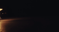 a man riding a skateboard down a street at night