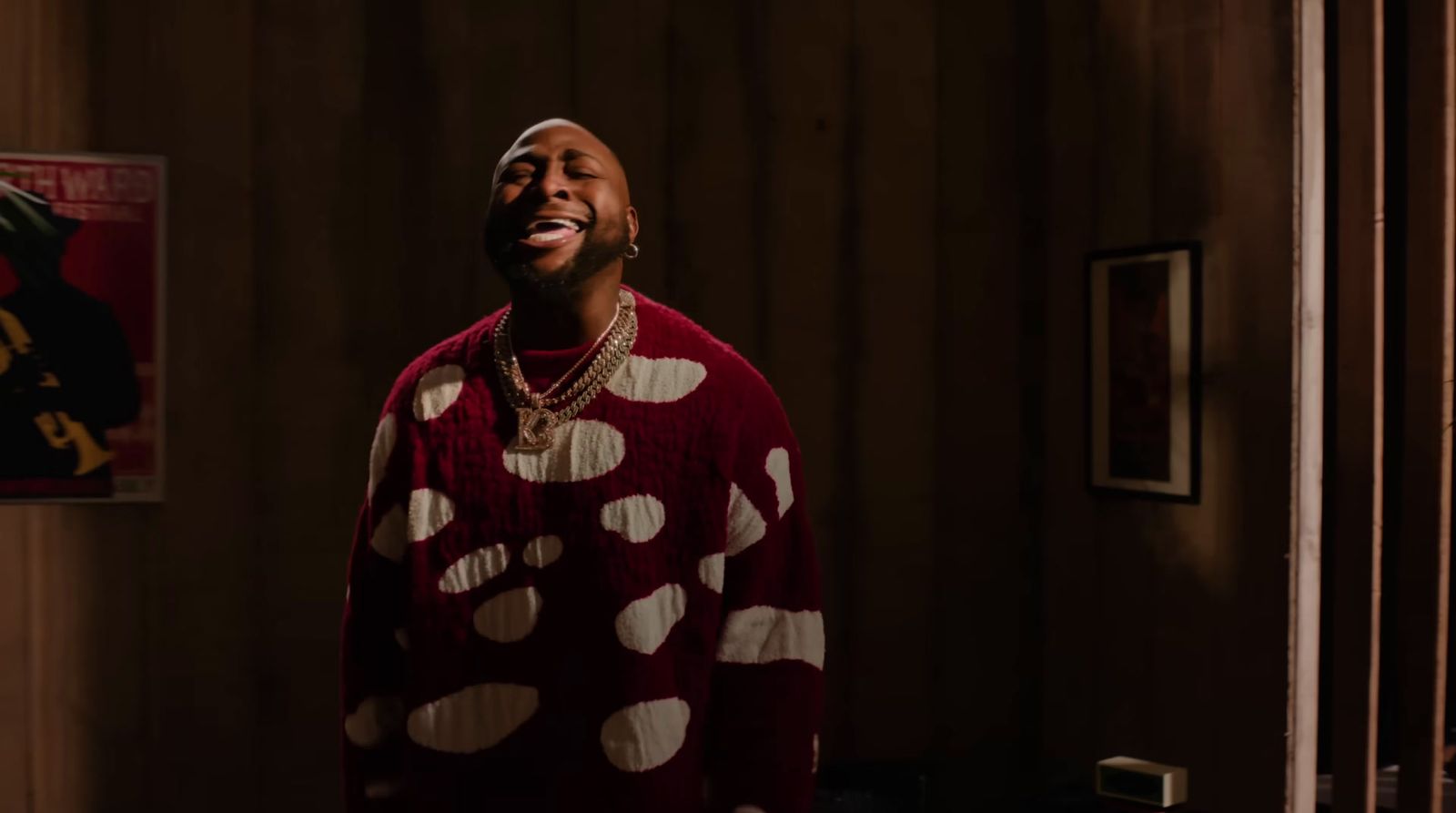 a man in a red and white sweater standing in a room