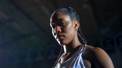 a woman with braids standing in a dark room