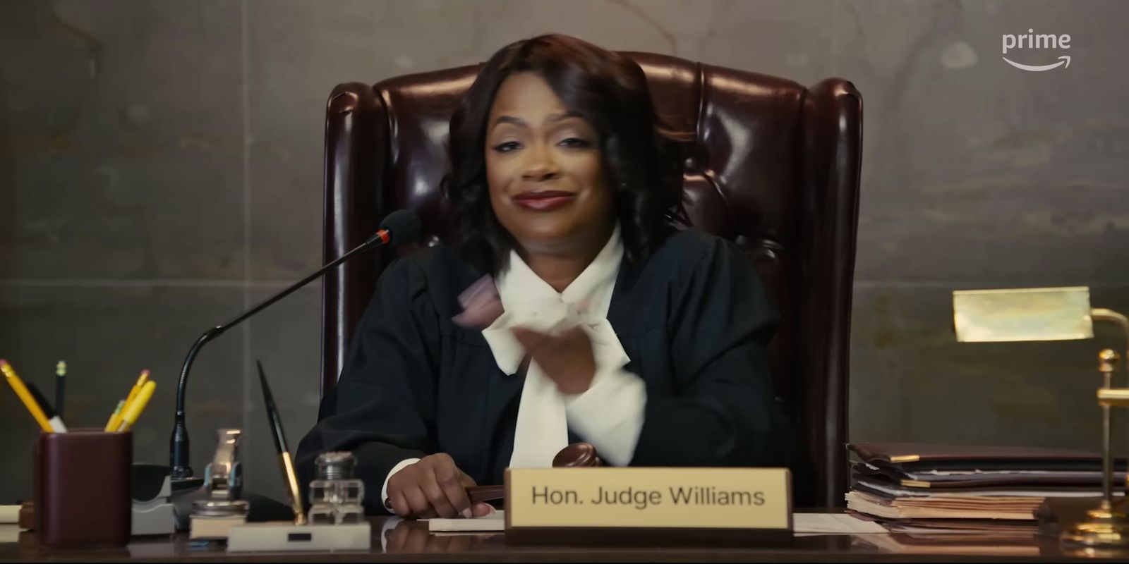 a woman sitting at a desk in front of a microphone