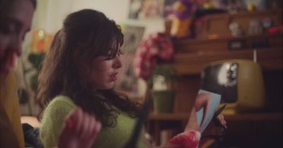 a young girl is reading a book in a living room