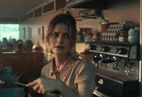 a woman in a kitchen with a spoon in her hand