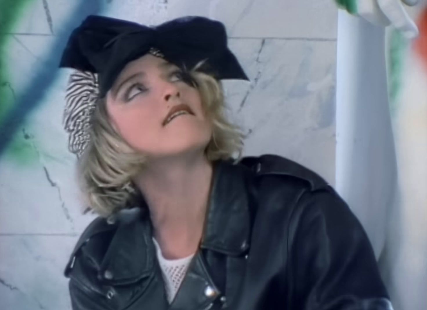 a woman wearing a black hat and leather jacket