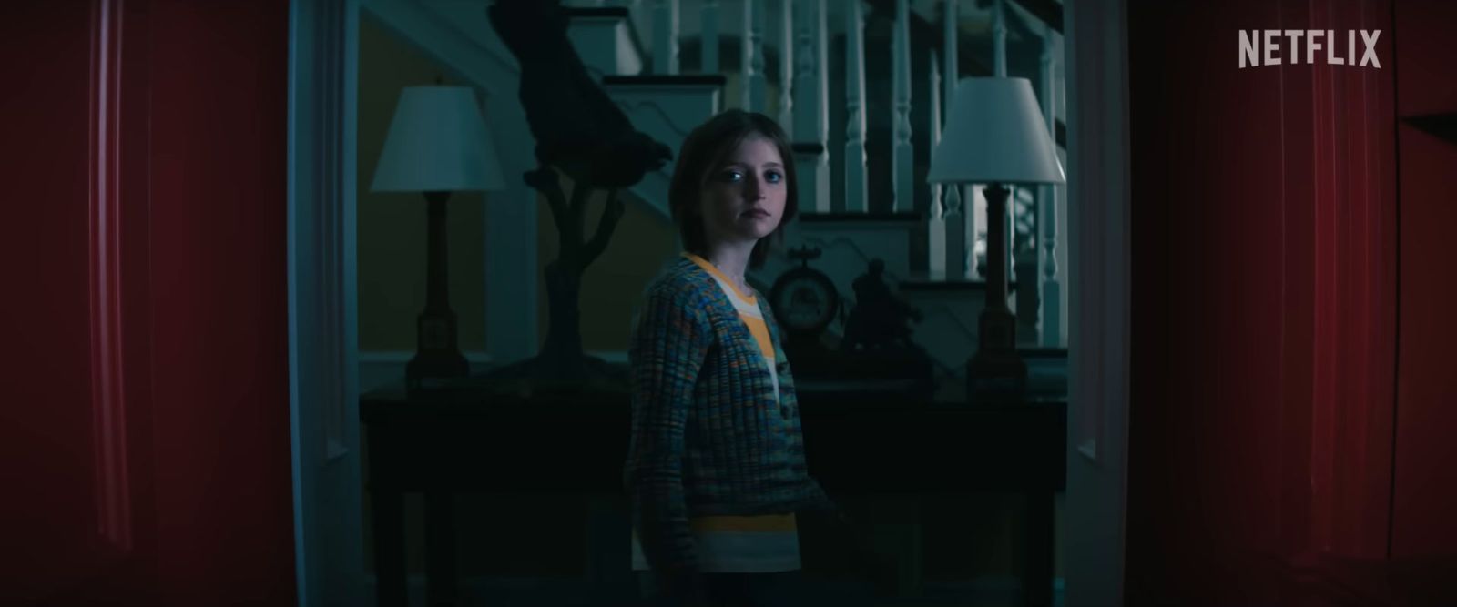 a woman standing in a room with a red curtain