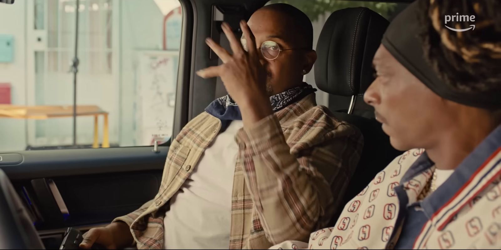 a man sitting in a car talking on a cell phone