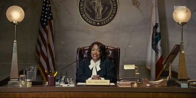 a woman sitting at a desk in front of an american flag