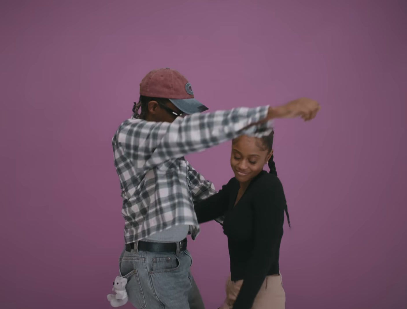 a man and a woman dancing together in front of a purple background