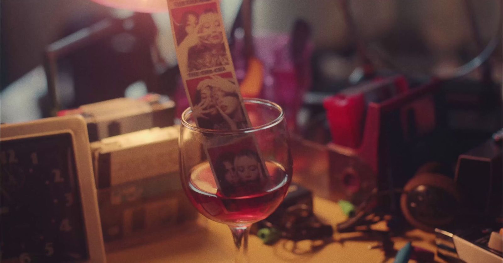 a glass of red wine sitting on top of a table