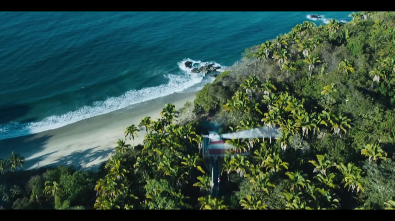 an aerial view of a plane flying over a beach