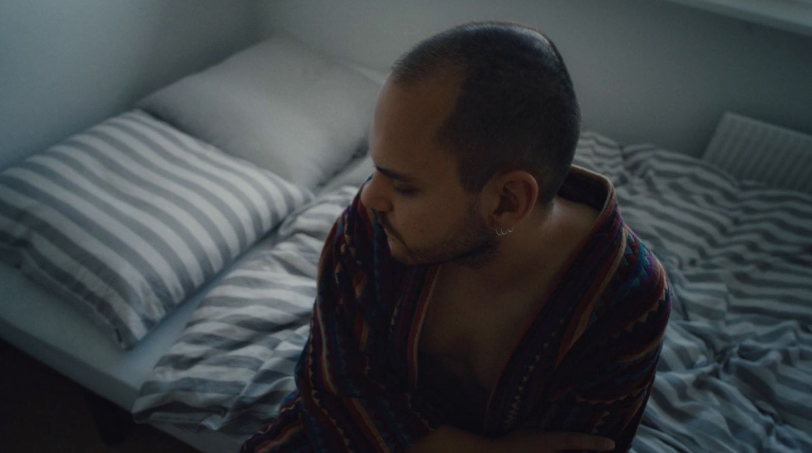 a man sitting on a bed in a bedroom