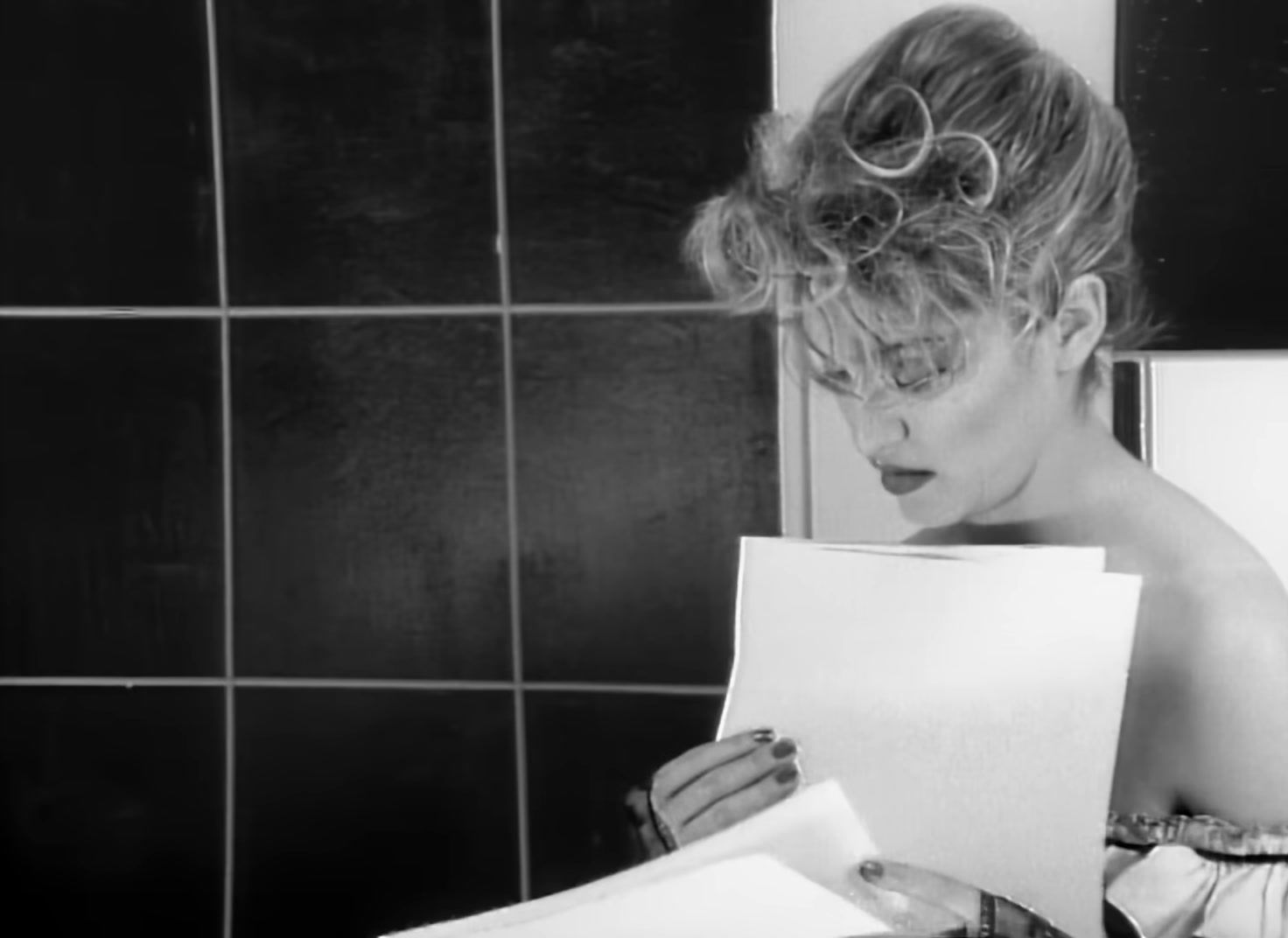 a woman reading a paper in a bathroom