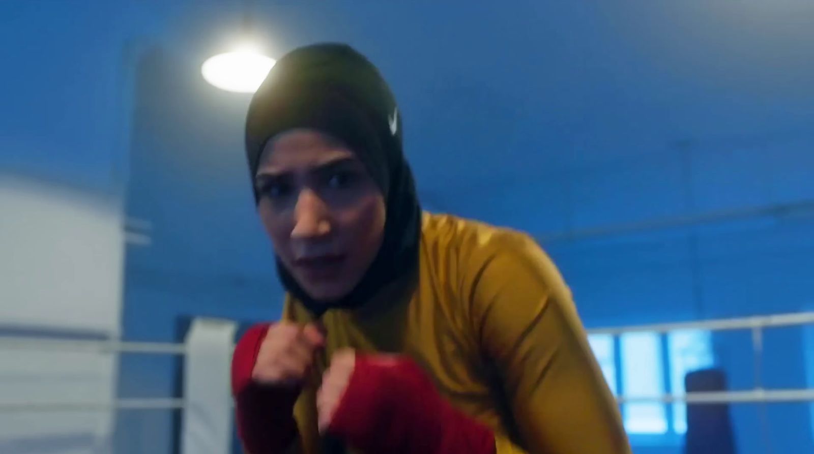 a woman wearing a yellow shirt and red gloves