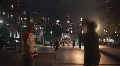 a group of people walking down a street at night