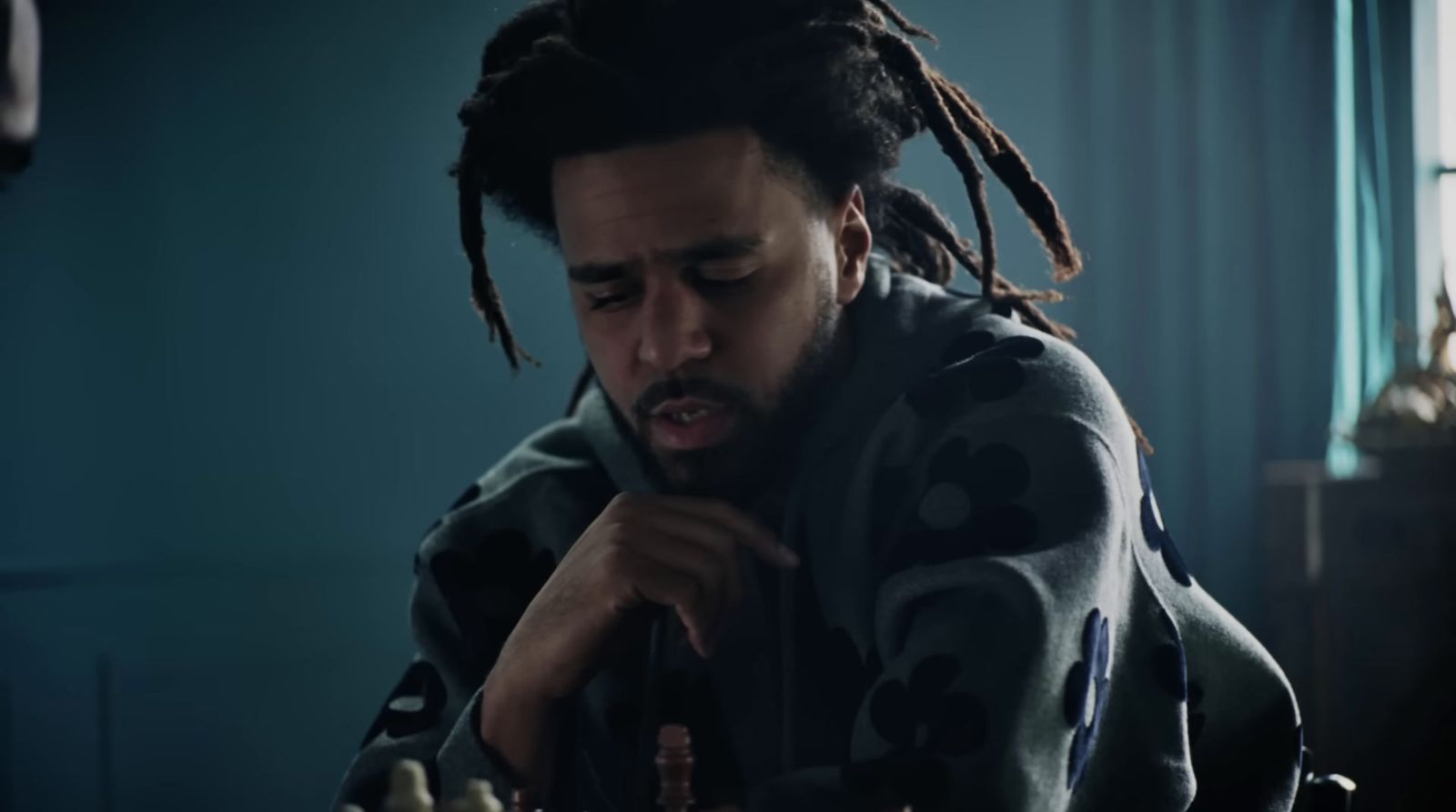 a man with dreadlocks playing chess