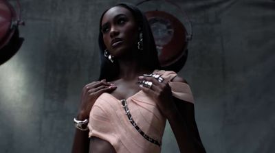 a woman in a pink dress standing in front of a wall