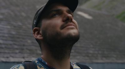 a man with a baseball cap looking up into the sky