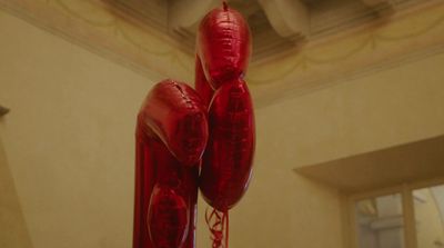 a pair of red balloons hanging from a ceiling
