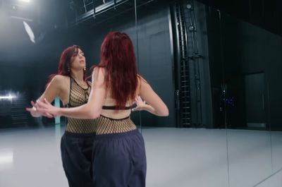 two women standing in front of a mirror in a room