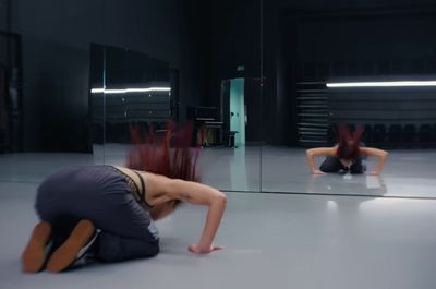 a woman kneeling down in front of a mirror