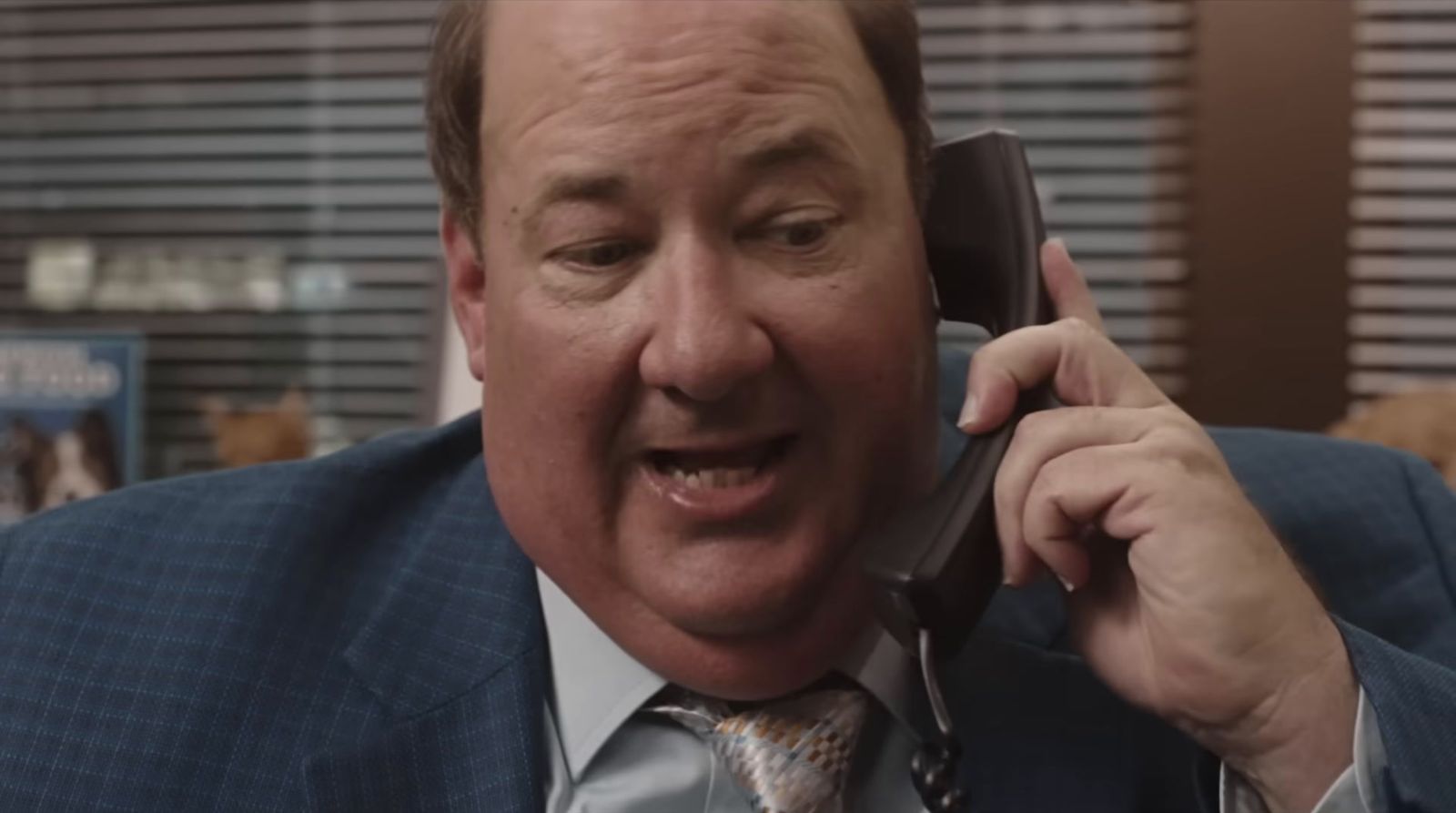 a man in a suit talking on a cell phone