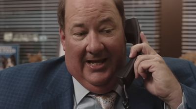 a man in a suit talking on a cell phone