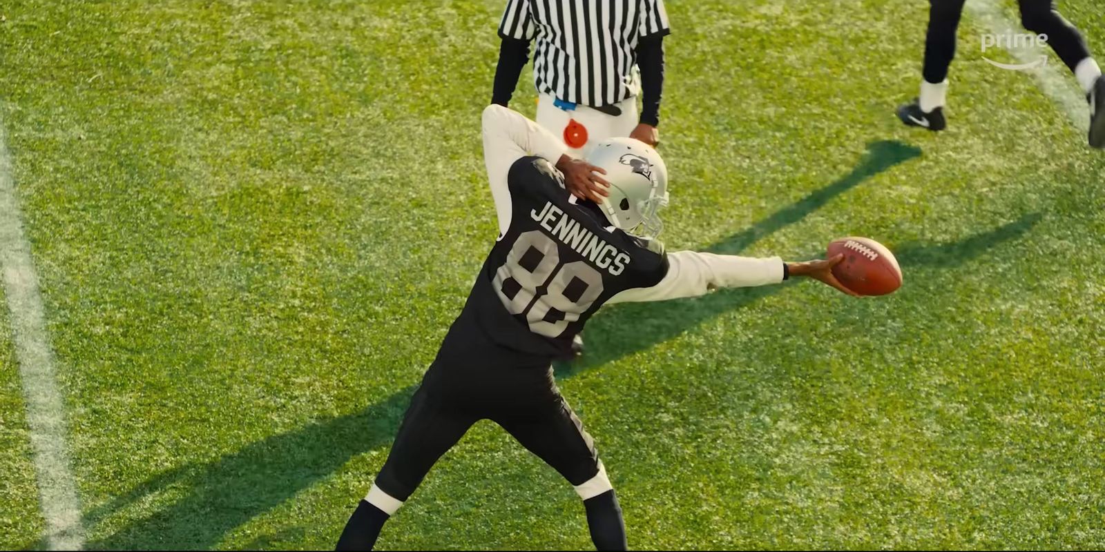 a football player holding a football on top of a field