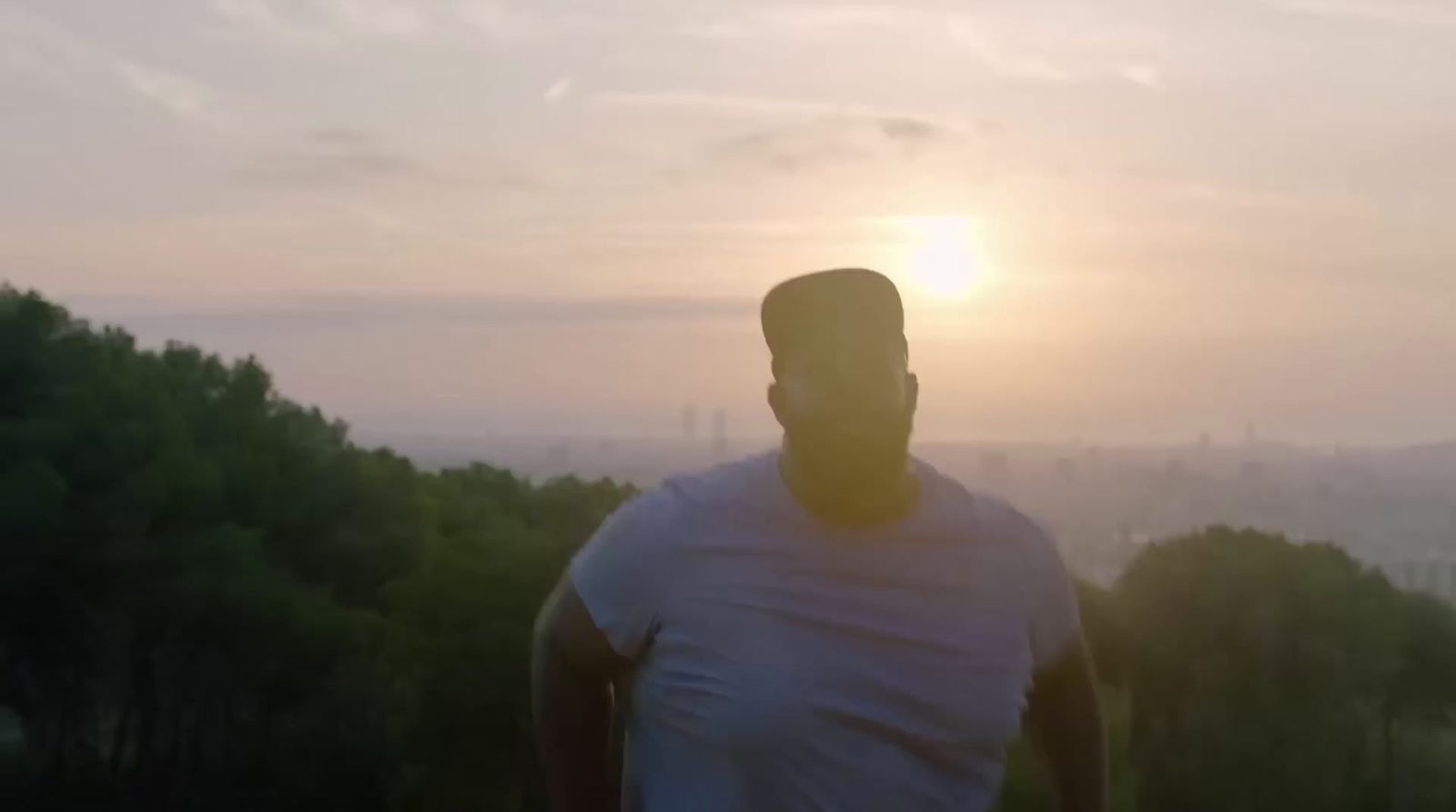 a man standing in front of a sunset