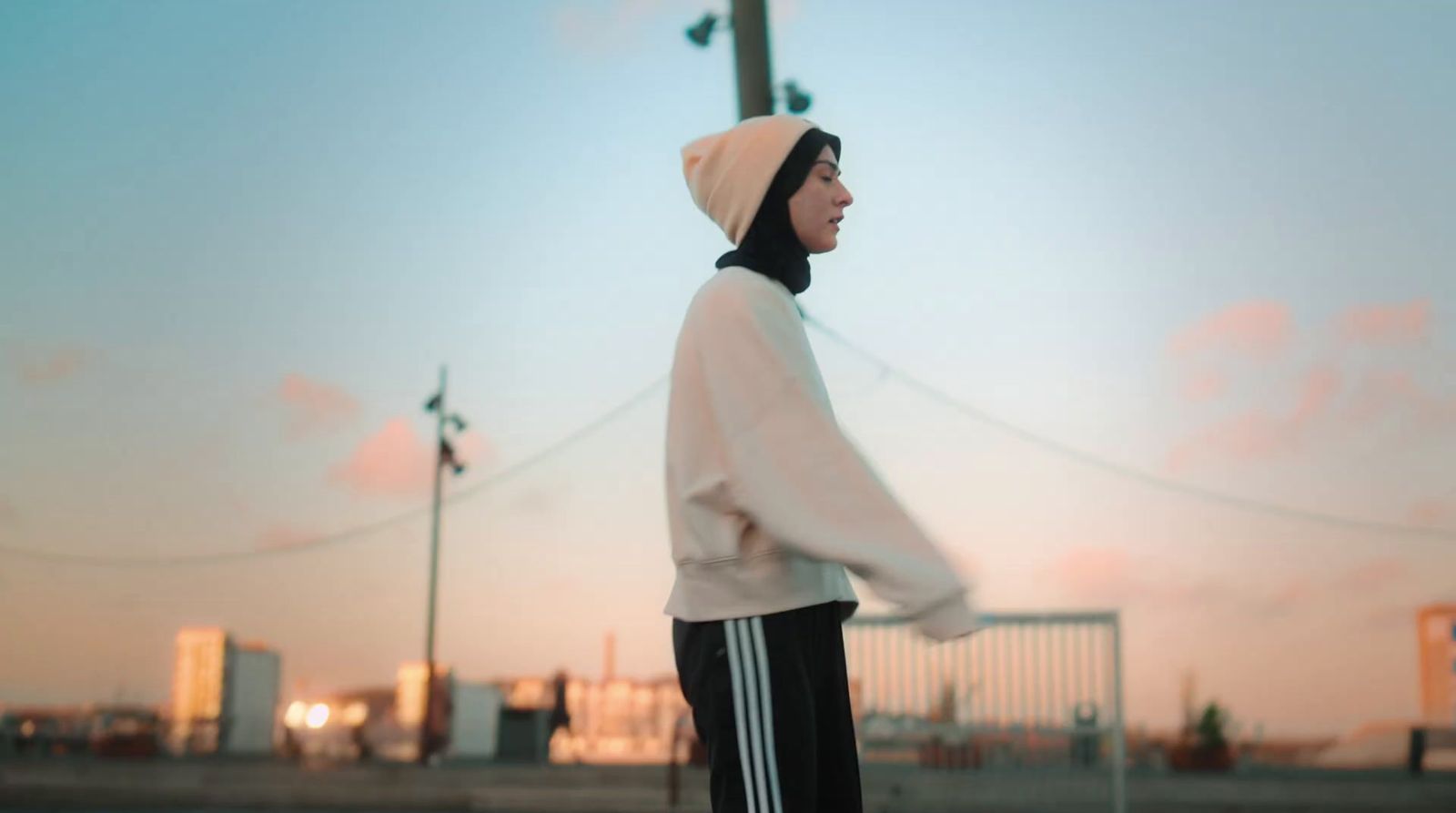 a man in a hoodie is standing on a skateboard