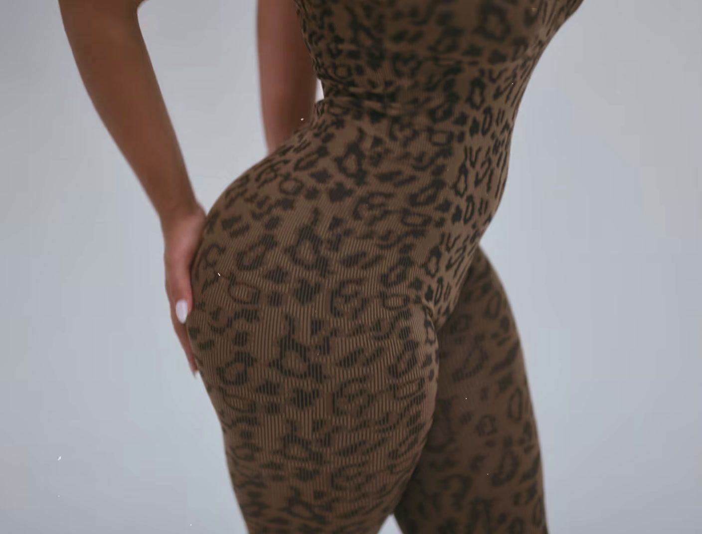 a woman in a leopard print bodysuit posing for a picture