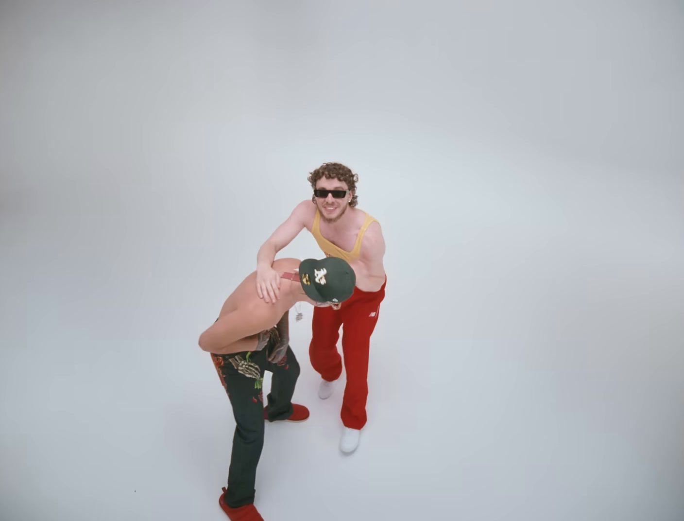 a man holding a frisbee while standing next to another man