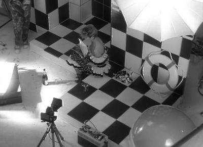 a woman sitting on a checkered floor in a bathroom