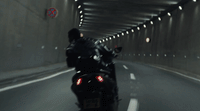 a man riding a motorcycle down a tunnel