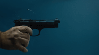 a hand holding a gun in the water