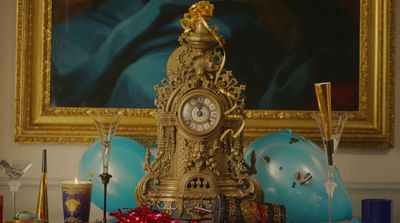 a gold clock sitting on top of a table