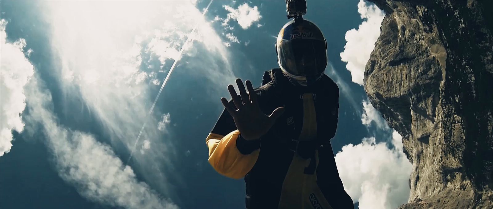 a man in a helmet standing in front of a mountain