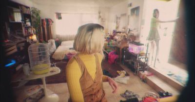 a woman standing in a room full of clutter