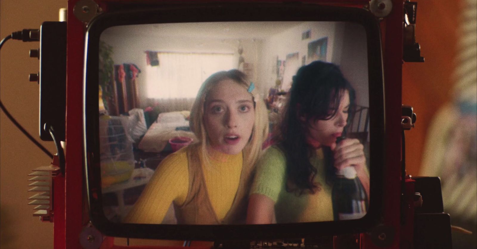 a tv with two girls on it in a room