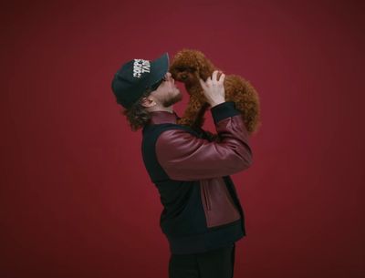 a man holding a dog in his right hand