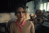 a woman standing in a kitchen next to a stove