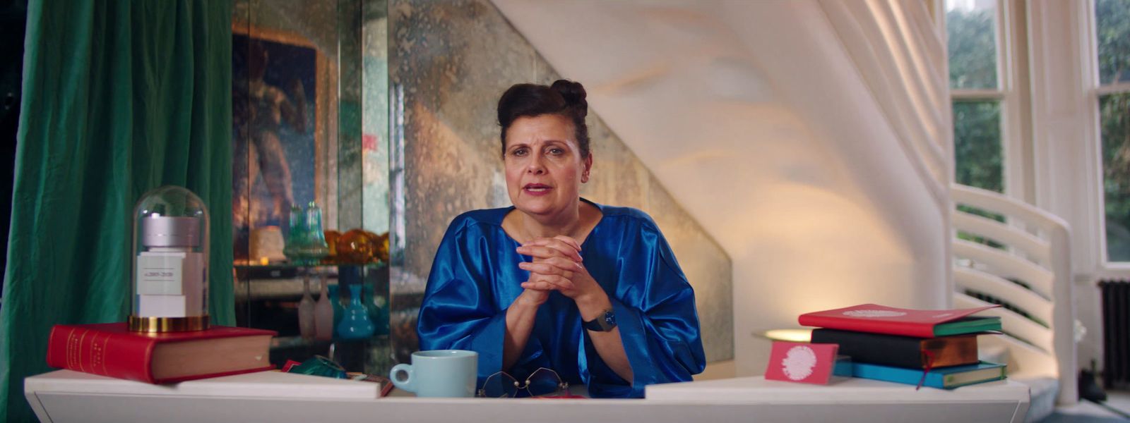 a woman sitting at a table with a bunch of books