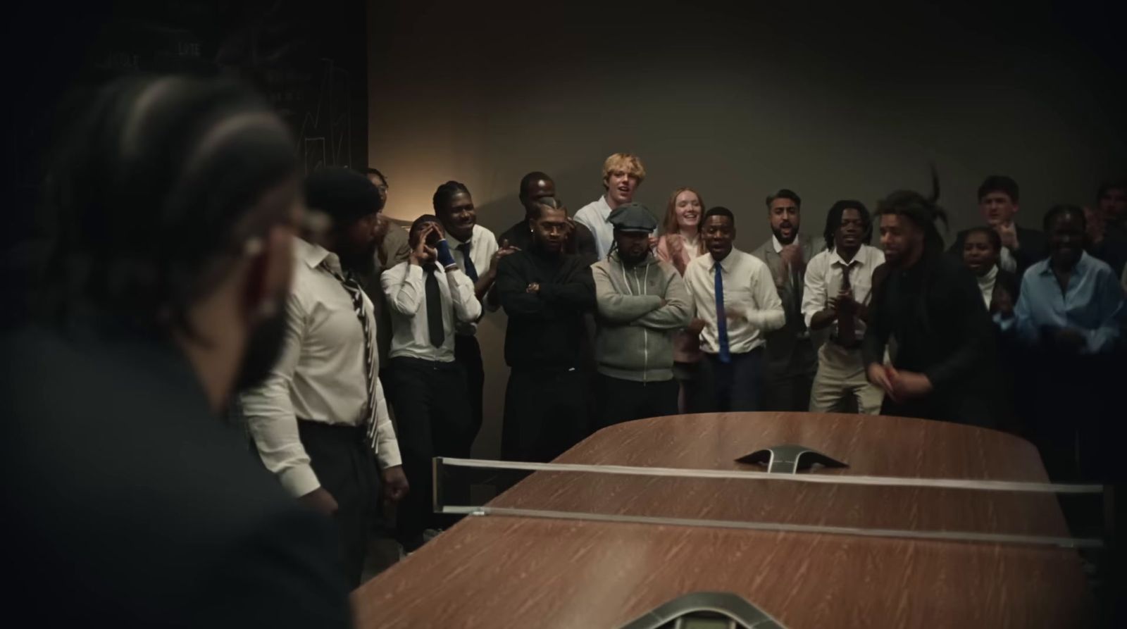 a group of people standing around a wooden table