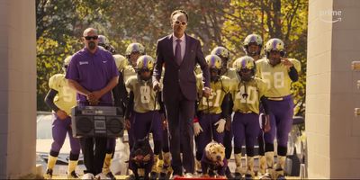 a man standing in front of a group of football players