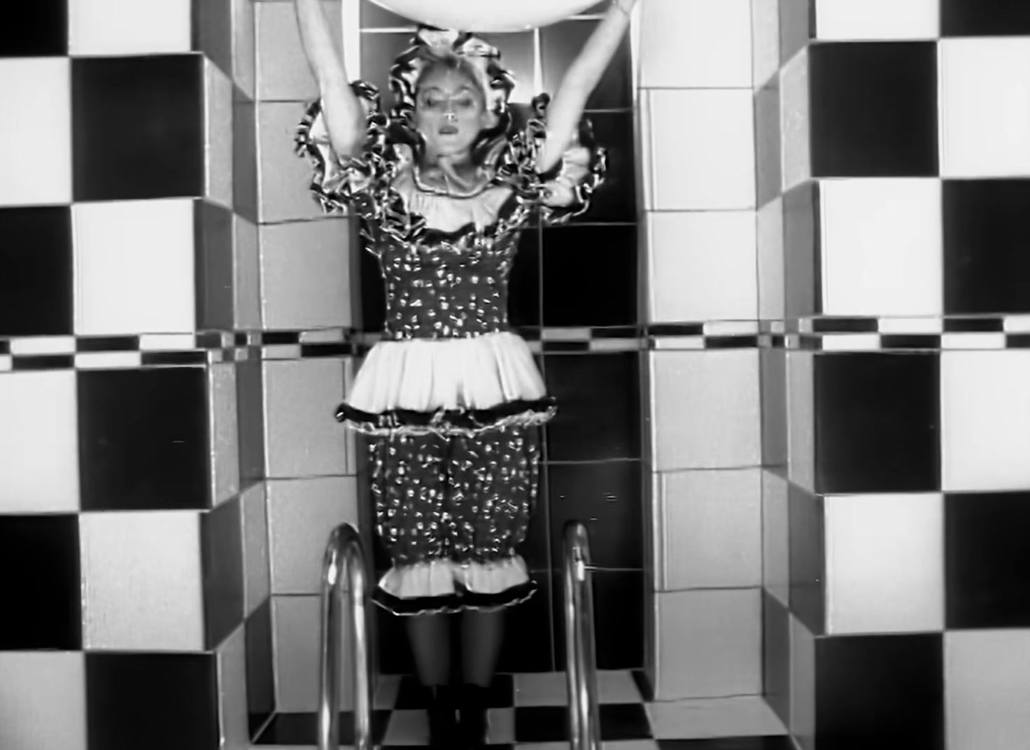 a woman standing in front of a mirror in a bathroom