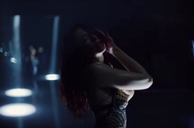 a woman is dancing in a dark room