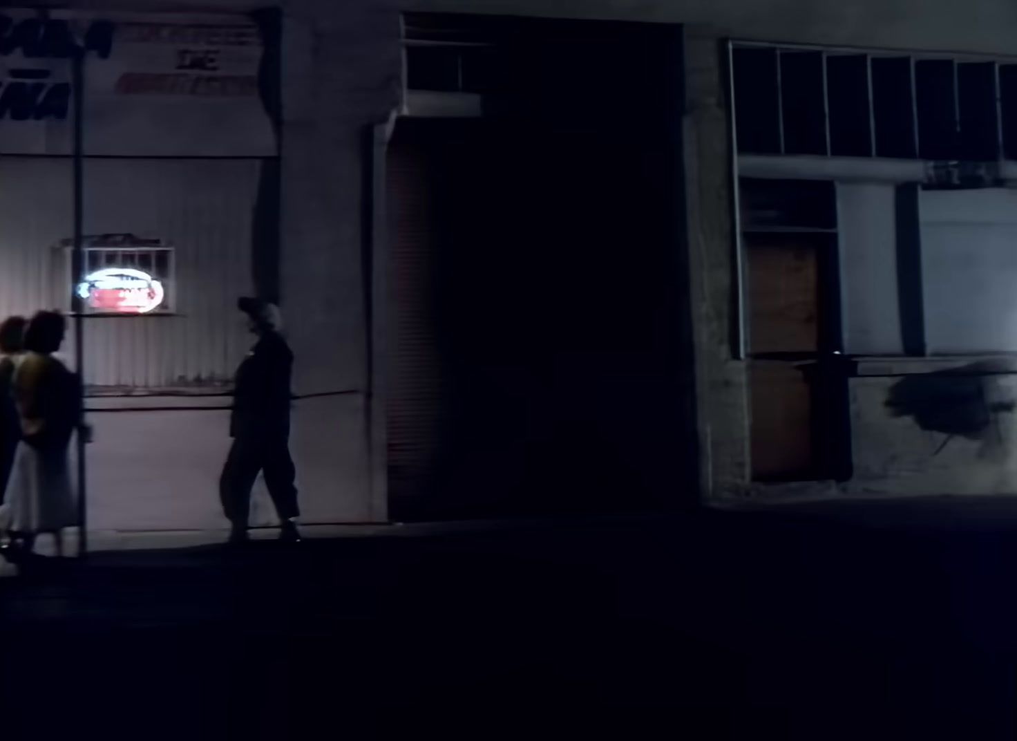 a group of people standing outside of a building at night