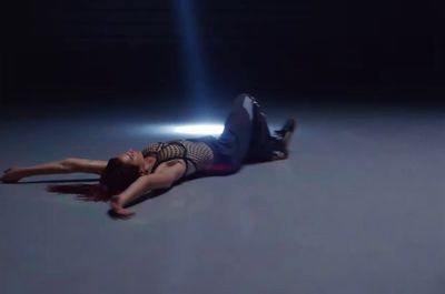 a woman laying on the ground in the dark