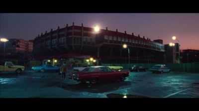 a red car parked in a parking lot next to a building