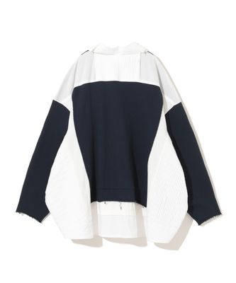 a black and white sweater hanging on a hanger