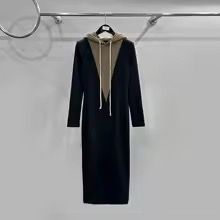 a long black coat hanging on a clothes rack